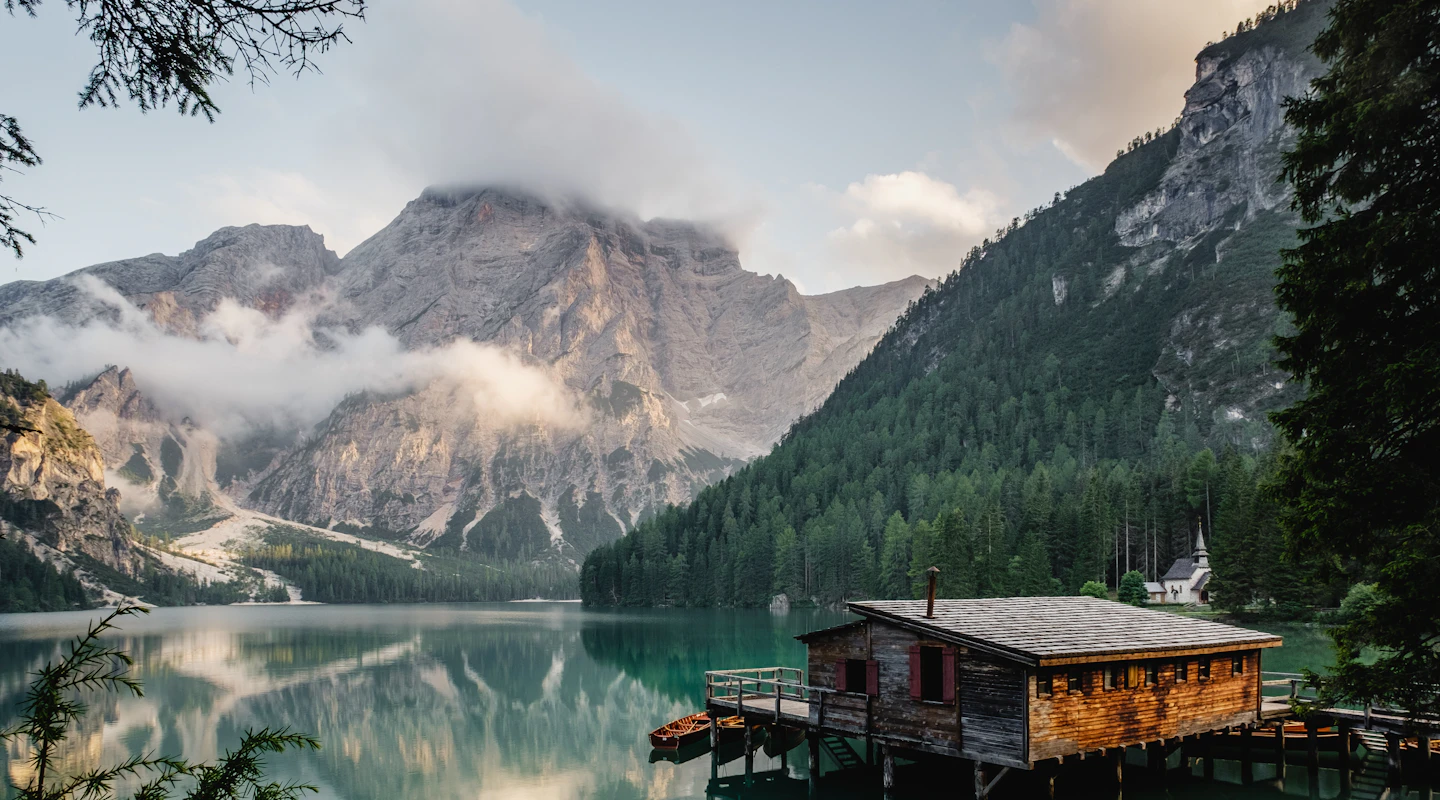 Photograph of the Dolomite mountains reflected in a turquoise alpine lake