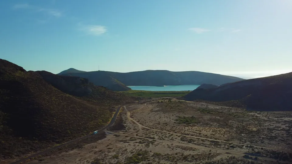 An aerial mountain lake view comparing before and after views to show terrain and road details
